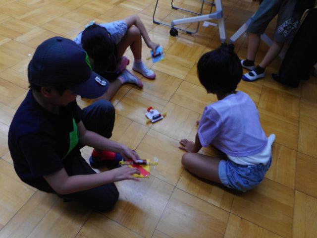 完成したモーターカーを床で走らせて楽しむ子どもたち