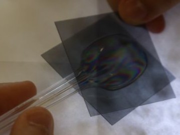 2枚の偏光板を重ね、見え方の変化を確かめている様子