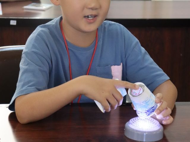 完成した万華鏡を手に持ち、みんなに作品を発表する子ども