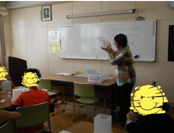 ホワイトボードを使って足踏み式ごみ箱の仕組みを説明する様子