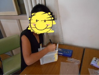 組み立てたごみ箱にペンで絵や色を加える児童